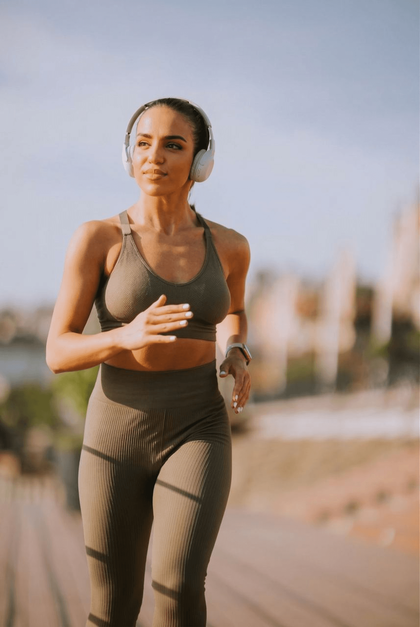 Active woman running outdoors with headphones