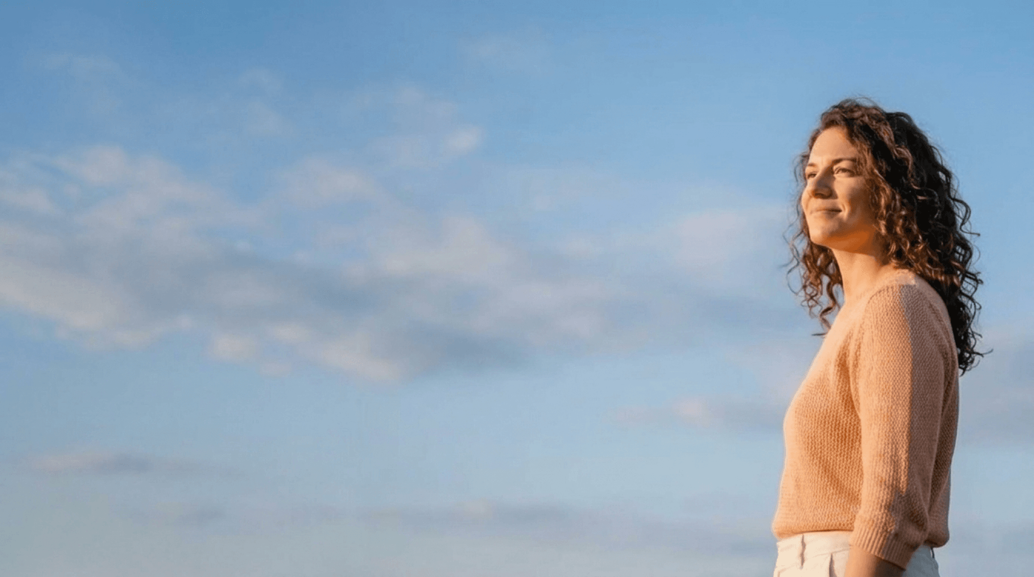 Woman in warm golden light, at ease with herself mid-life